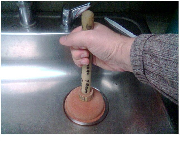 unclog the kitchen sink with a plunger
