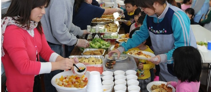 a group of neighbors serving food at a gathering