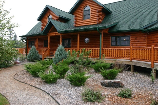 A nicely landscaped log cabin home.