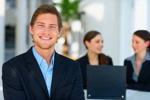 man in office environment smiling