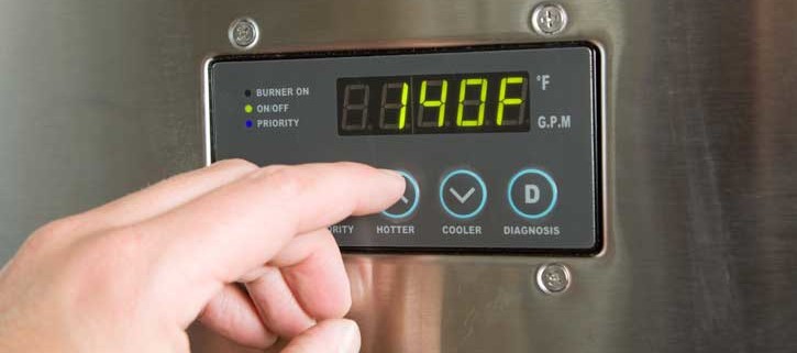 a person's fingers touching control panel of tankless water heater