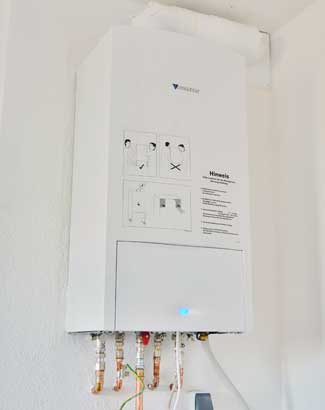 white tankless water heater attached to a wall