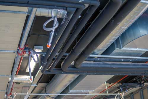 plumbing pipes running through ceiling along with HVAC system