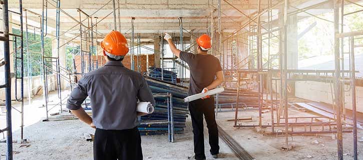 Two men discussing a building project at the site