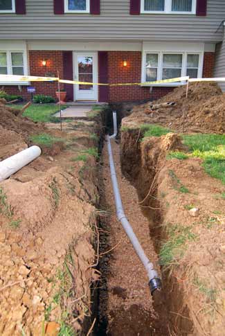 house with trench showing main sewer line