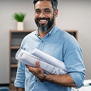 Smiling man holding blueprints