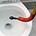 someone using a drain snake or auger to unclog toilet